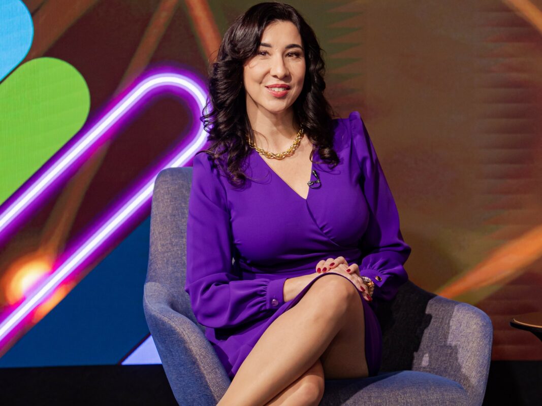 Portfolio in English 2 moderator konferencji siedzi na scenie w fioletowej sukience